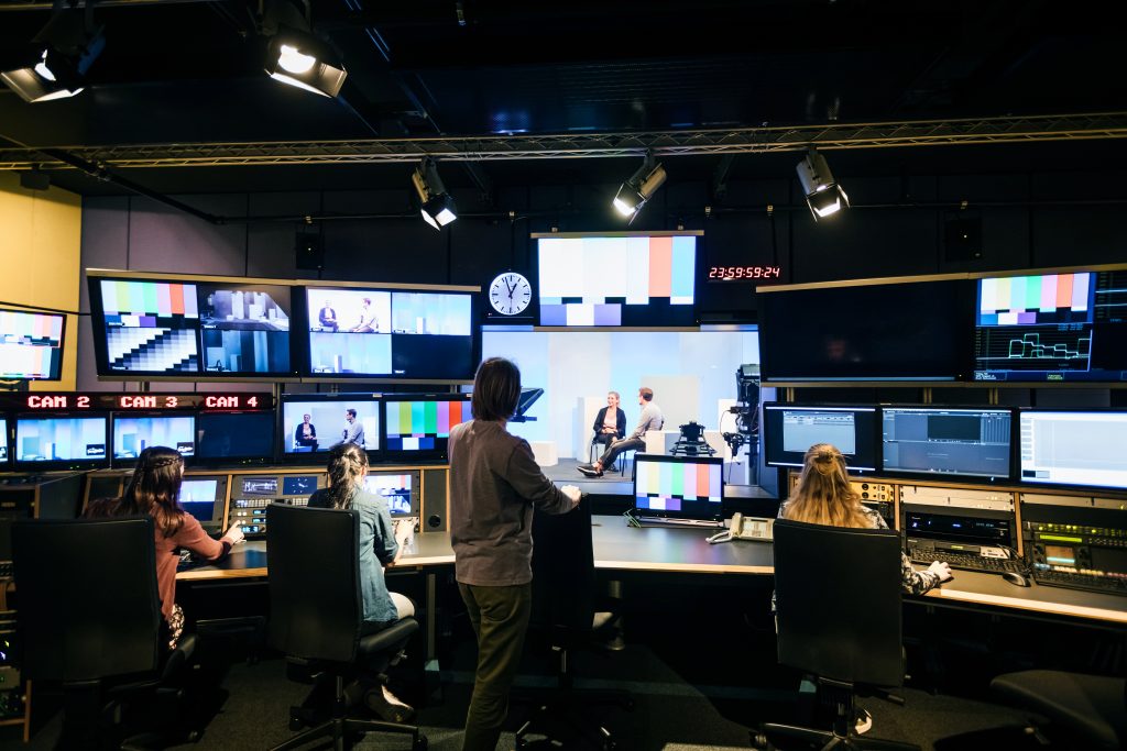Nesta imagem podemos ver um estúdio de TV, onde é possível acompanhar algumas métricas como a frequência e a audiência, o que é importante para saber para anunciar na TV.