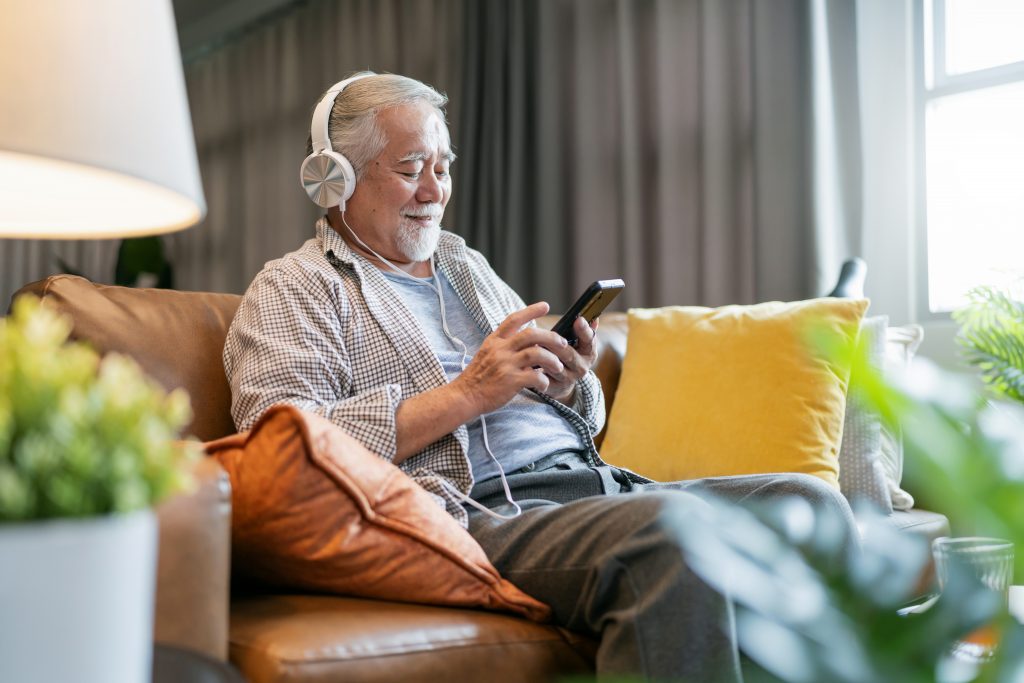 Nesta imagem podemos ver um senhor escutando podcast. Os podcasts no Brasil conquistaram o coração de todos os públicos.