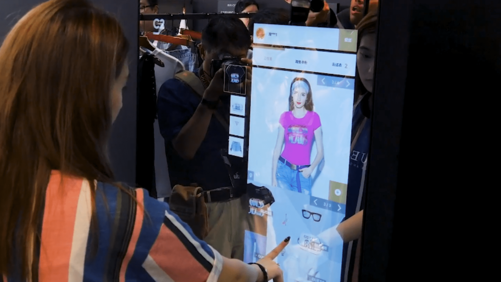 Nesta imagem podemos ver uma mulher escolhendo as roupas por meio de inteligência artificial.A inteligência artificial no marketing pode ser utilizada para te auxiliar a alcançar seus objetivos corporativos.