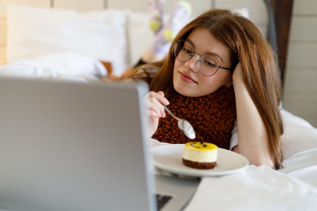 Nesta imagem podemos ver uma moça que parece assistir algum conteúdo no computador.Produzir e consumir conteúdo com mais calma é a base do slow content.