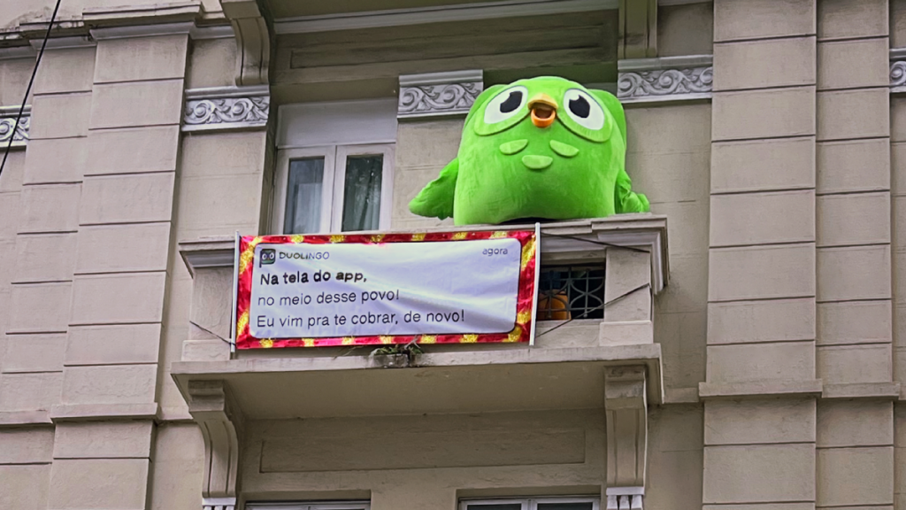 Nesta imagem podemos ver o Duo na sacada de um hotel, comemorando o carnaval. O estudo de caso Duolingo é de muito sucesso.