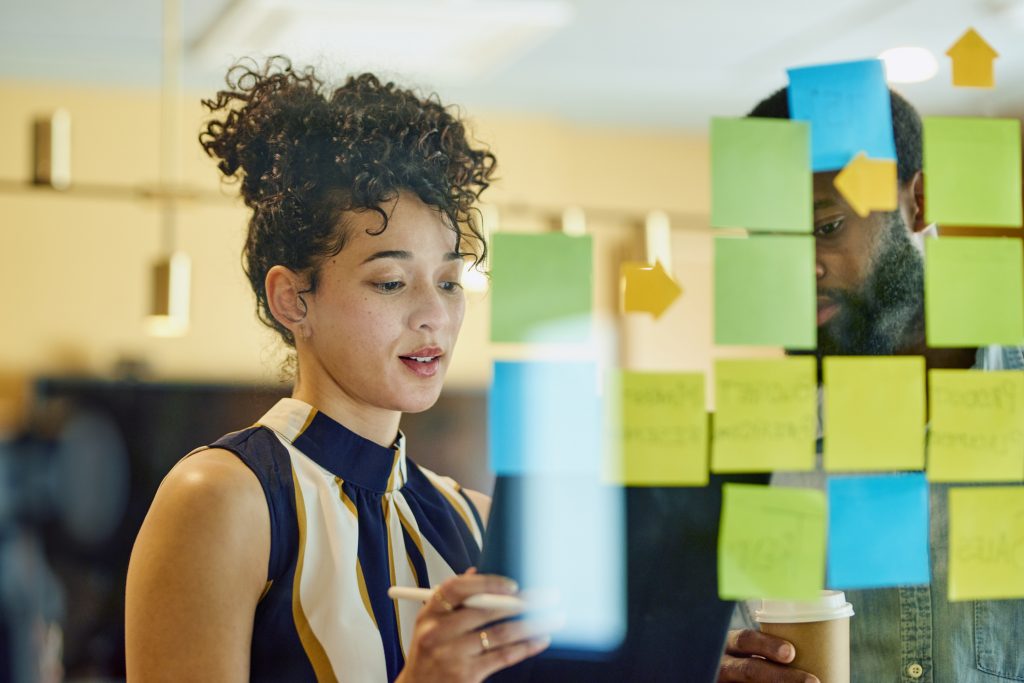 Dois profissionais de negócios discutindo ideias de como trabalhar maximizando o ROI em um escritório.