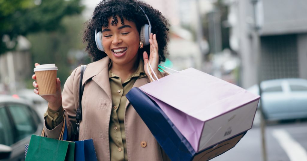 Fones de ouvido, saco de compras ou mulher feliz na cidade para venda de varejo boutique, ou oferta de desconto de roupas.