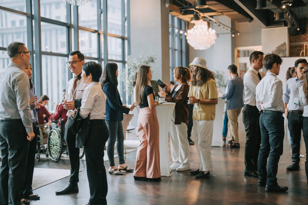 Empresários multiétnicos falam durante uma pausa para o café na feira de sua empresa, que apoio patrocínio de eventos.