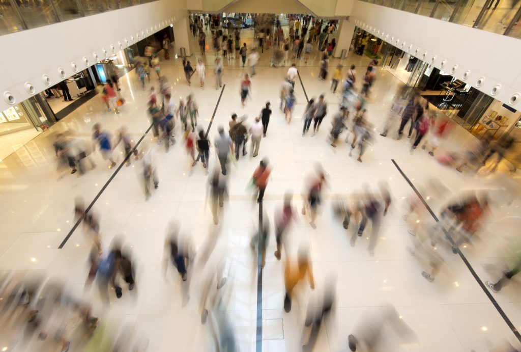 Foto tirando do alto onde é possível ver pessoas andando em shopping.