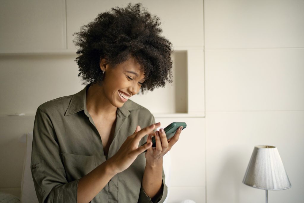 Mulher negra fazendo compras online em casa atenta. Ela está usando a economia da atenção.