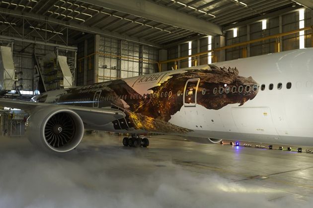 Avião com envelopamento do dragão do filme O Hobbit. Exemplo de mídia out of home em transportes.