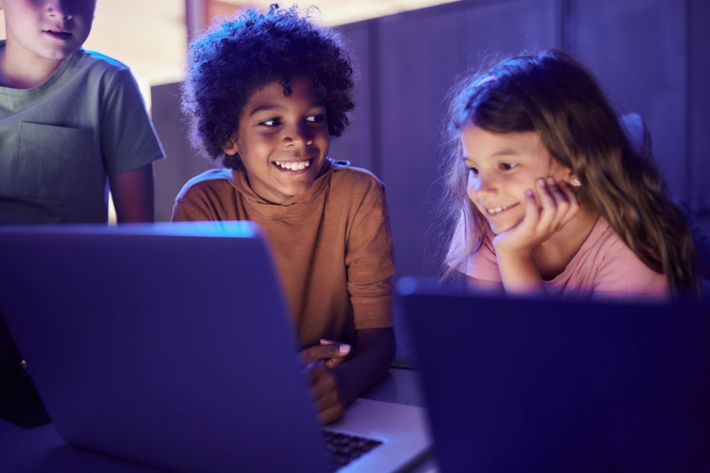 Crianças felizes navegando na Internet em um computador.