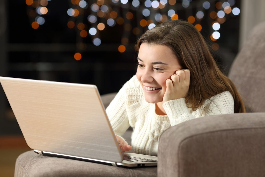 Adolescente usando um laptop em casa no meio da noite.