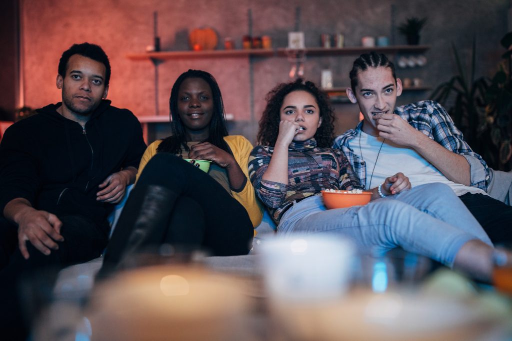 Amigos multiétnicos assistindo TV