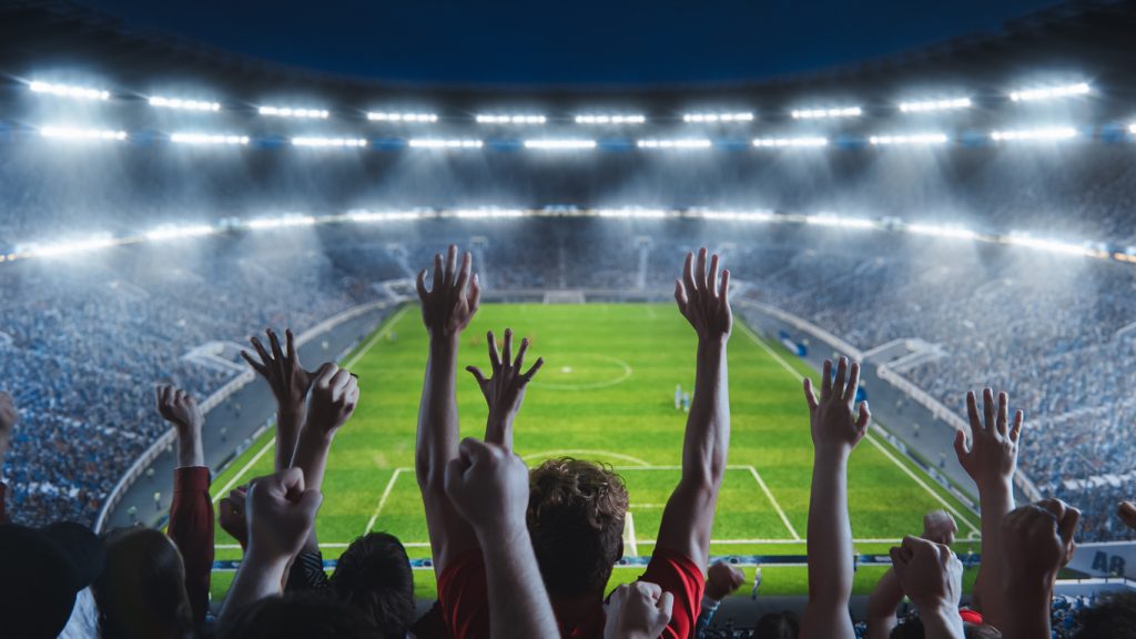 Times jogam, torcida comemora vitória enquanto acompanha o patrocínio no futebol.