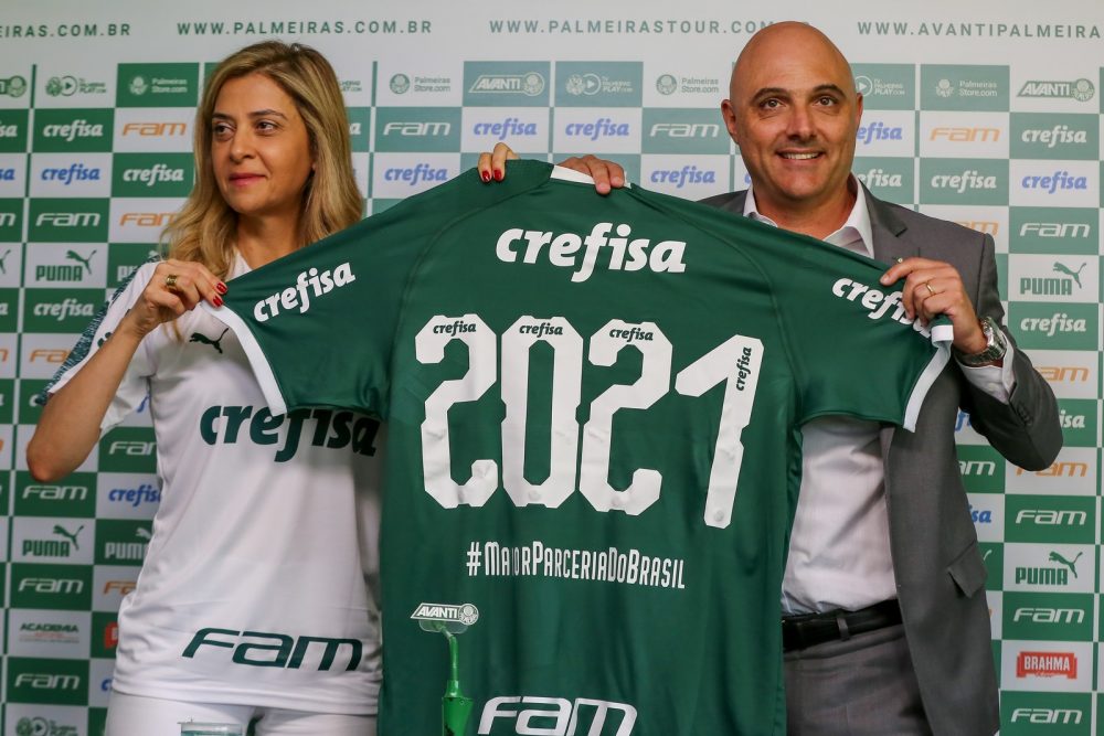 Leila Pereira segurando a camisa do Palmeiras com o patrocínio no futebol da FAM.
