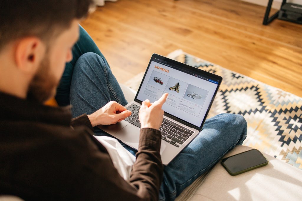 Homem escolhe tênis novinhos na loja online.