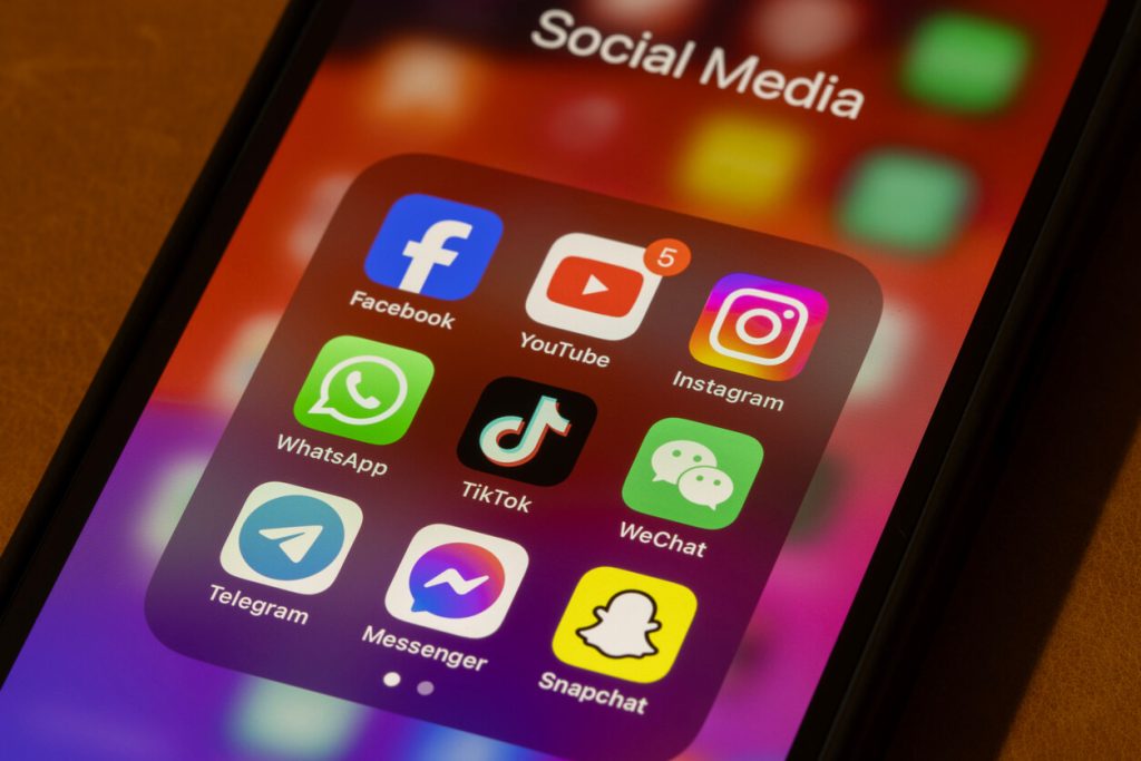 Principais plataformas de mídia social na tela de um celular, como Instagram, TikTok, Facebook e YouTube. Elas são muito utilizadas por criadores e influenciadores.