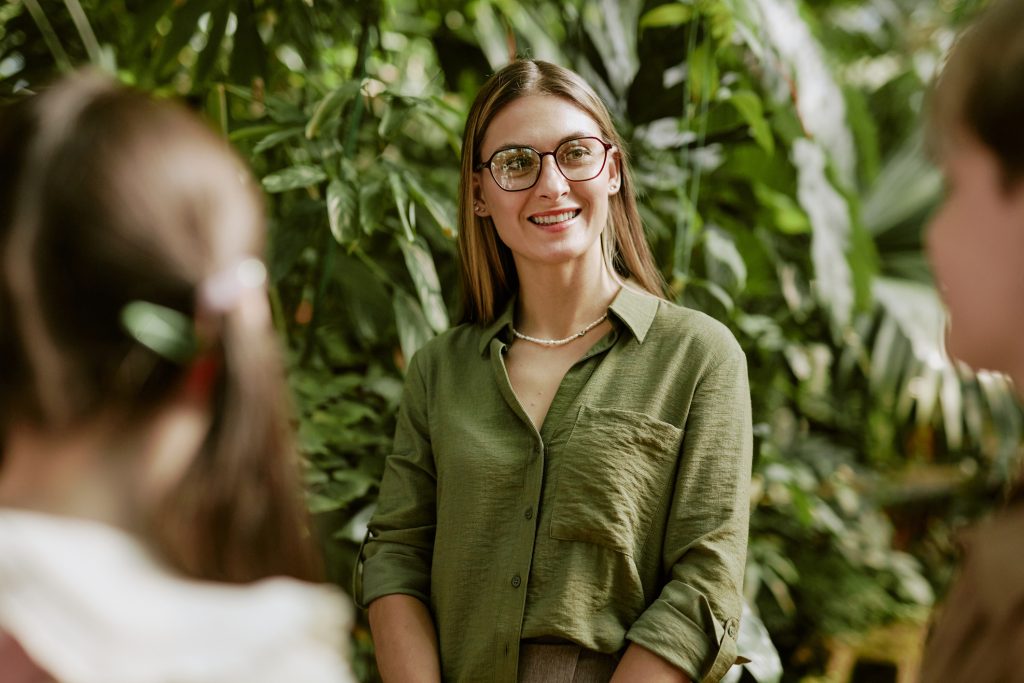 Mulher loira usa blusa verde e óculos e explora as tendências de turismo.