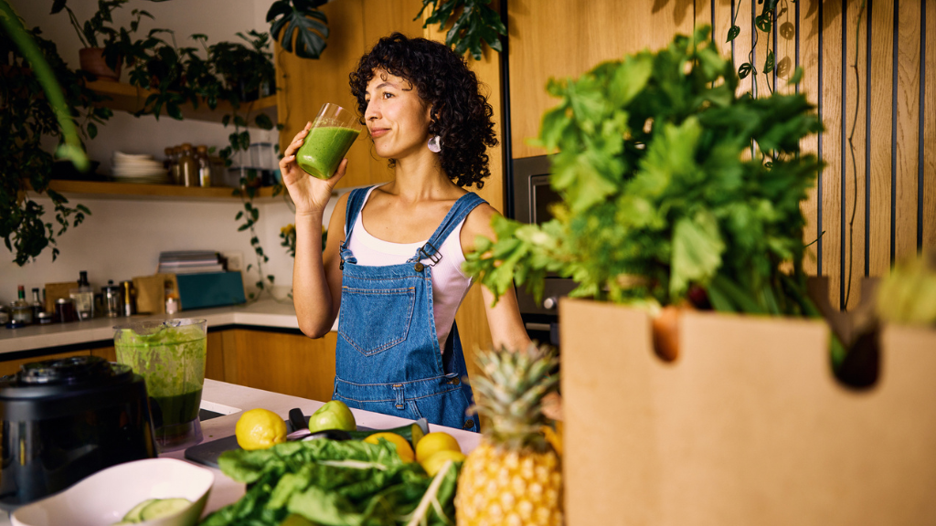 Uma pessoa jovem em um ambiente de escritório moderno e iluminado, segurando um copo de água ou bebida funcional refrescante, simbolizando o foco em produtividade que altera o consumo de álcool no Brasil.