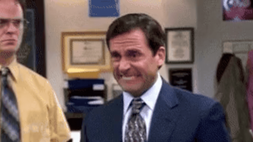 Michael Scott da série The Office faz expressão de constrangimento, representando a tensão e as perdas causadas pelo Gap de Inteligência Social nas empresas.