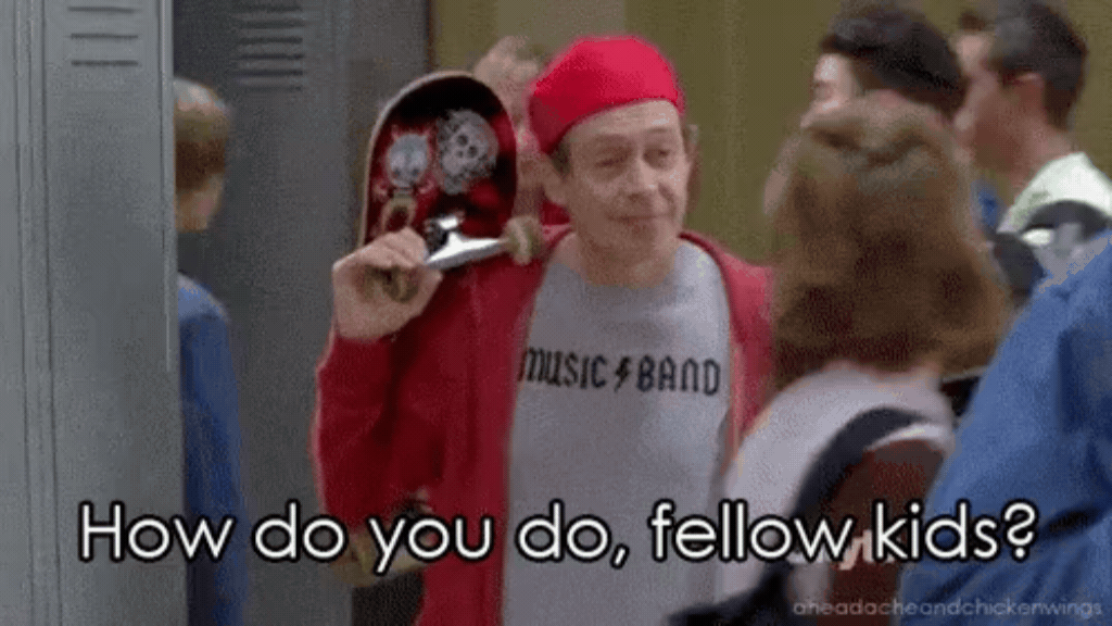 ma captura de tela do ator Steve Buscemi interpretando um homem de meia-idade disfarçado de adolescente em um corredor de escola. Ele usa um boné vermelho virado para trás, um casaco de moletom vermelho aberto sobre uma camiseta cinza escrita "MUSIC⚡BAND" e carrega um skate apoiado no ombro direito. Ele conversa com jovens de costas. Na parte inferior, há a legenda em letras brancas "How do you do, fellow kids?".