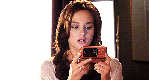 saturacao-de-midia-rendimentos-decrescentes-gossip-girl.gif GIF da personagem Blair Waldorf olhando para a tela do celular com expressão de surpresa e frustração, representando o impacto da saturação de mídia nos resultados publicitários.